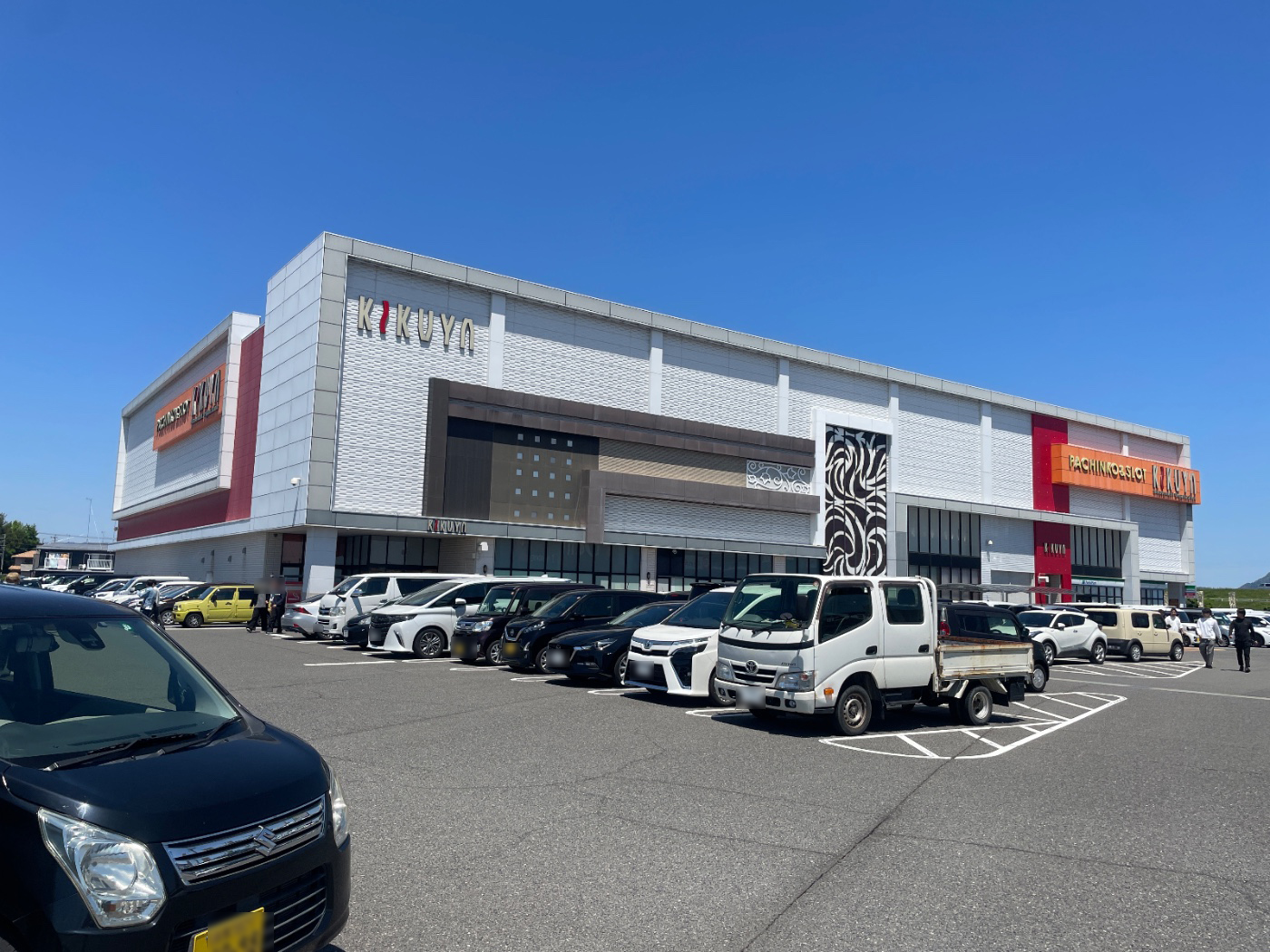取材班提供の店舗外観写真。「KIKUYA」のロゴが目立つ建物と、来店車両で埋まる広い駐車場の様子