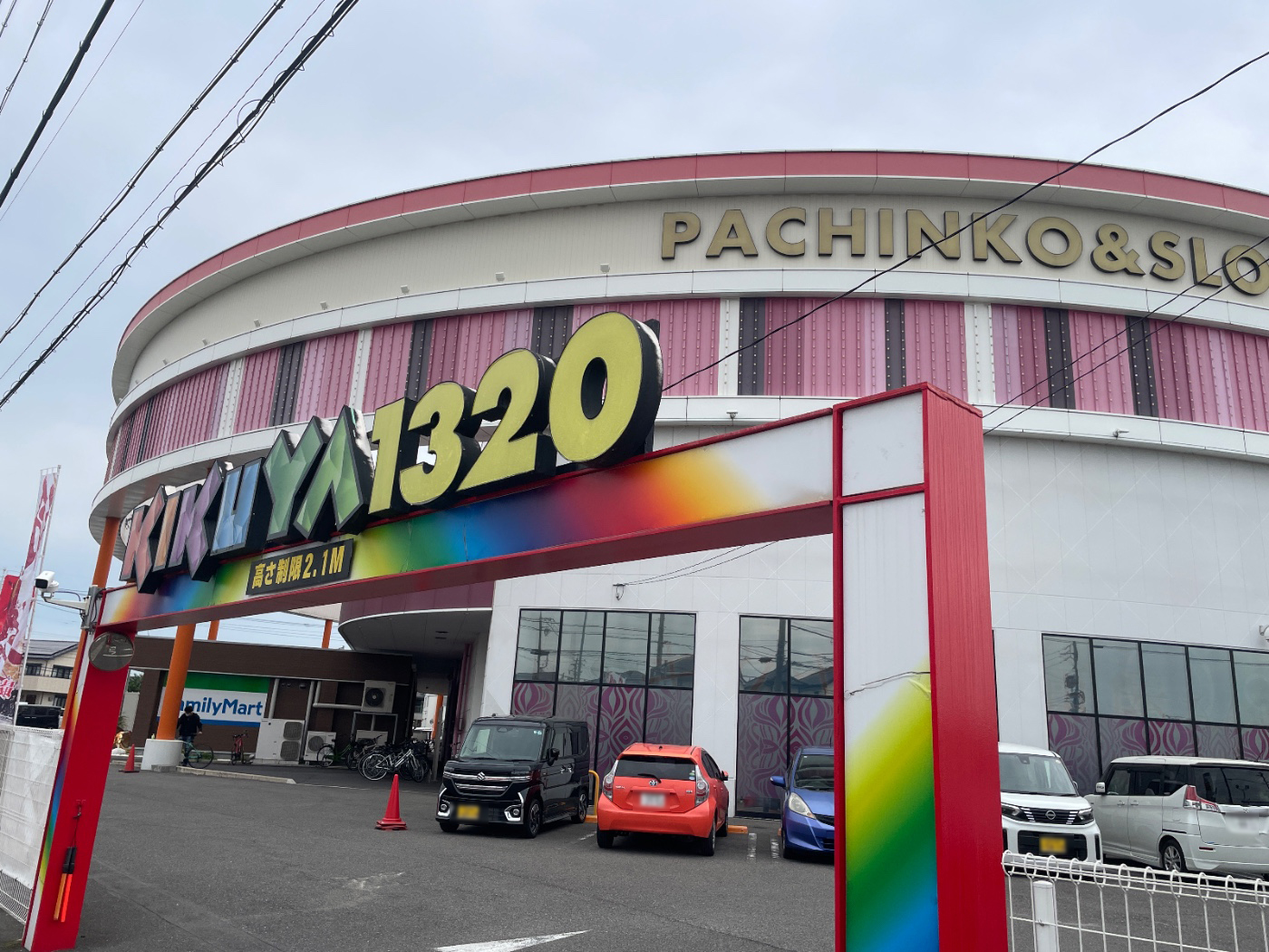 レインボーカラーのゲートに「KIKUYA1320」、円形の建物に「PACHINKO&SLOT」を掲げた店舗外観。