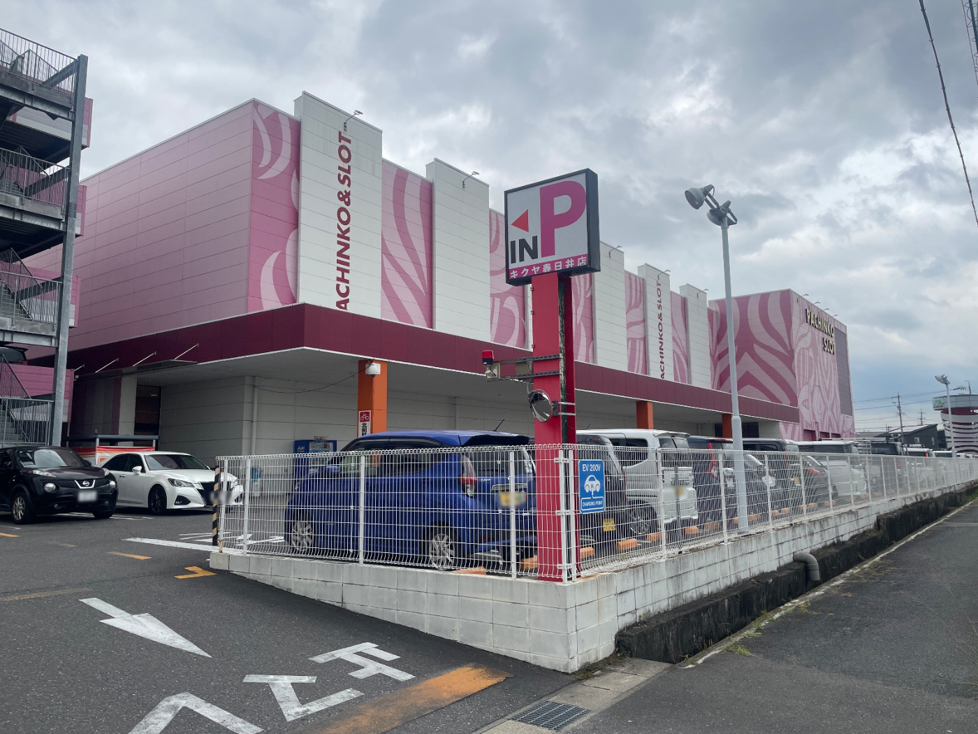 ピンクの外壁が目を引くキクヤ春日井店の外観。PACHINKO&SLOTの看板と広い駐車場が写っています