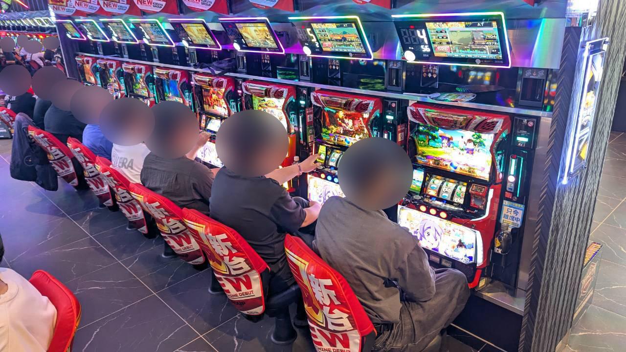 パチスロ島で多数の来場者が着席し遊技中